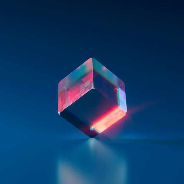 Red transparent cube balencing on a corner with a dark blue background